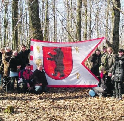 Prie akmens, į kurį, regis, šaknis įleidęs medis (dešinėje) suplazdėjo Žemaitijos vėliava.