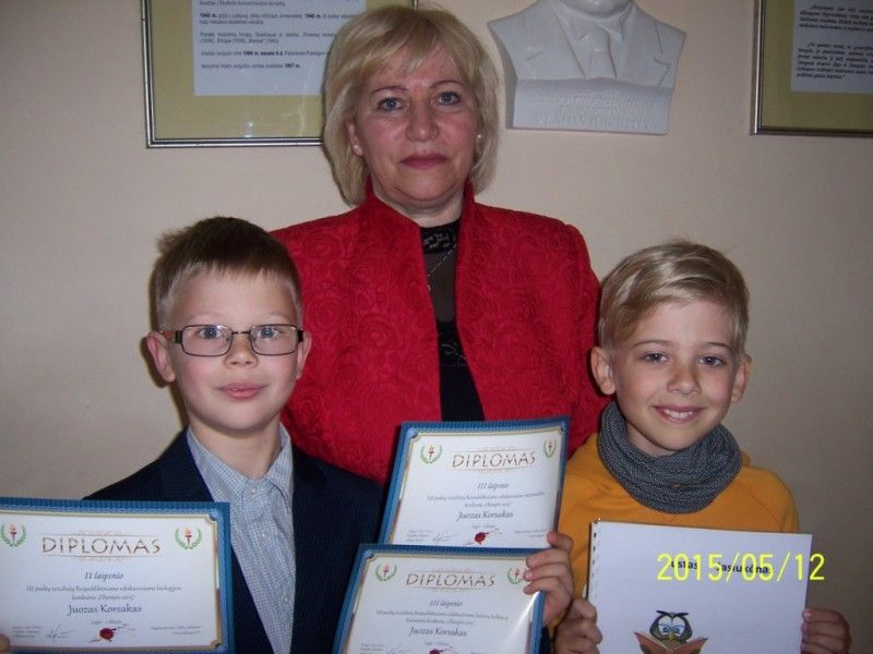 : jaunieji talentai J. Jasiukėnas (su savo knygele) ir J. Korsakas (su daug diplomų) su savo mokytoja E. Bendikiene.