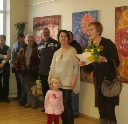 Mokytoja D. Rakauskienė perskaitė poetės ir kolegės E. Karnauskaitės sveikinimą, kurio klausėsi parodos autorė ir prie jos besiglaudžianti mažoji Gabija.