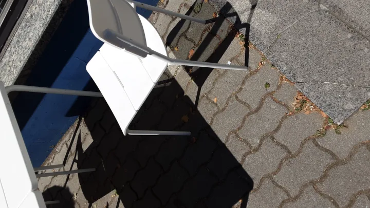 Prie kavinės dar nesugrėbti pernykščiai medžių lapai, o piktžolės veržiasi pro šaligatvio plyteles – nuotrauka 1