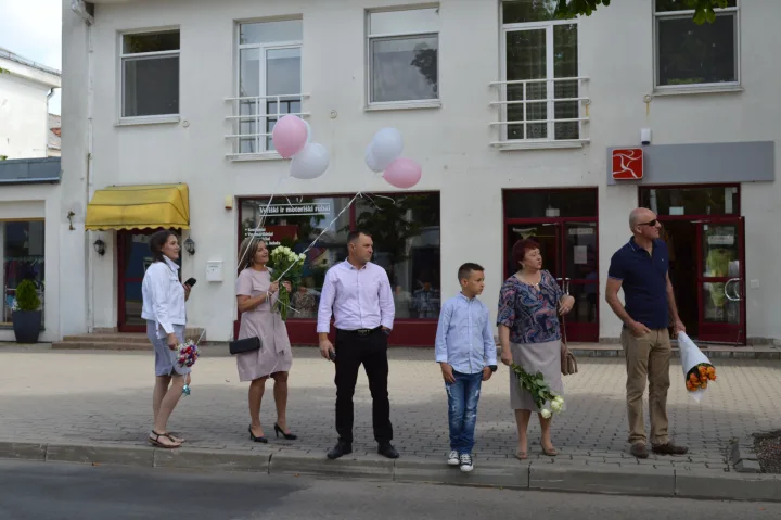 Šventinės eisenos nekantriai laukė gėlėmis nešini abiturientų artimieji.